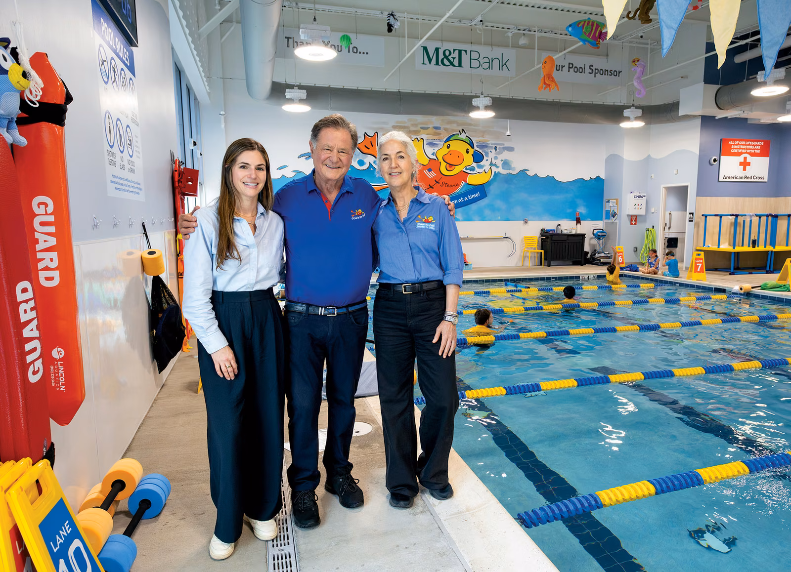 Stew Leonard Jr., Kim Leonard, and Ryann Leonard Grossbard beside a pool at a Stewie the Duck swim school